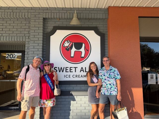Couples enjoy Inverness Food Tour in front of the City's mural